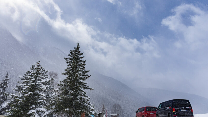 black and red VW vans surrounded by snowy mountains