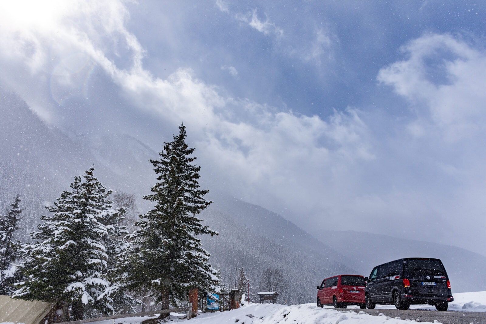 black and red VW vans surrounded by snowy mountains