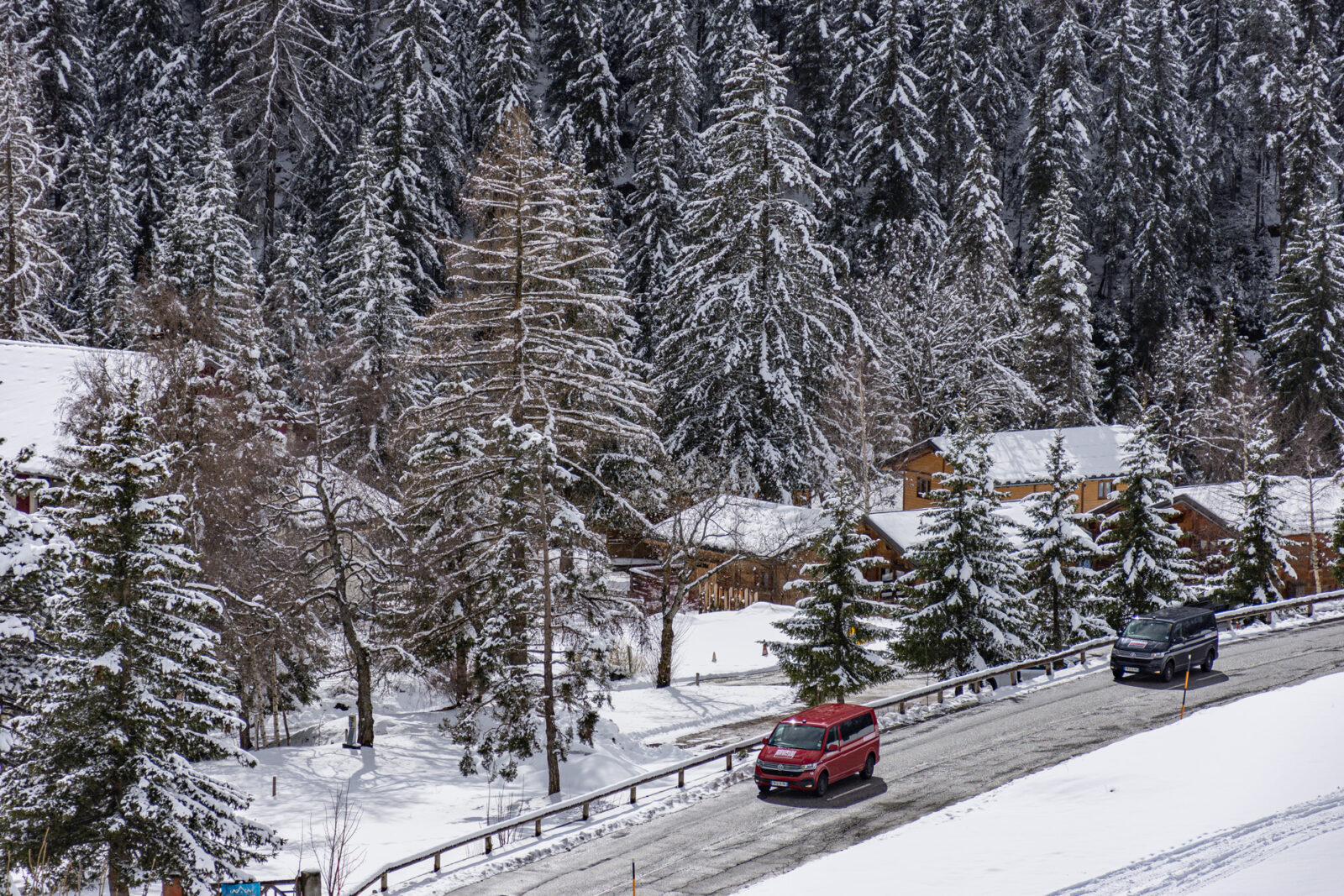 Two VW vans driving through a ski resort