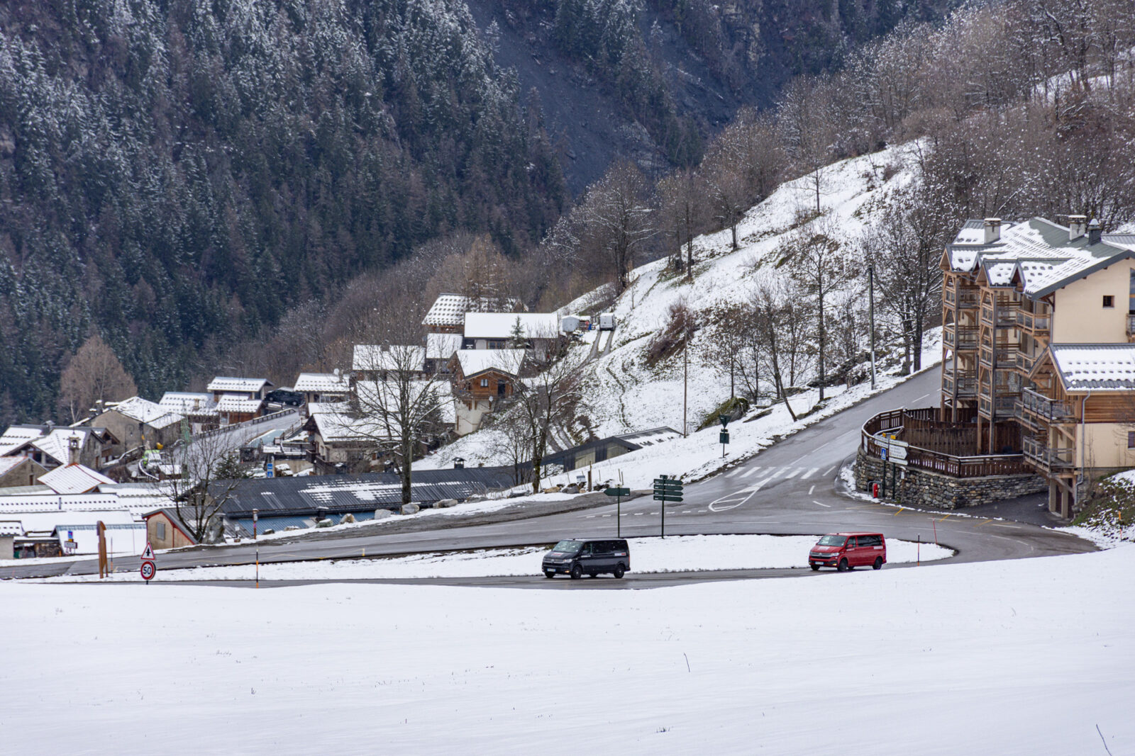Two ski transfer vans driving up winding mountain road