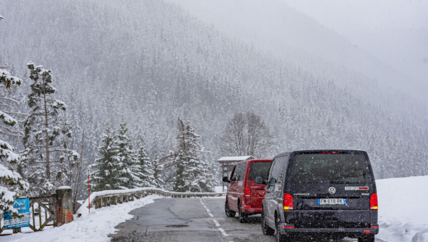 two vans on road in snowy mountains