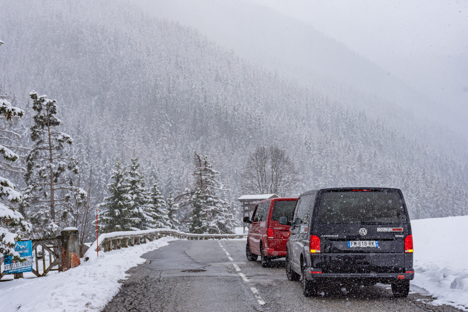 two vans on road in snowy mountains