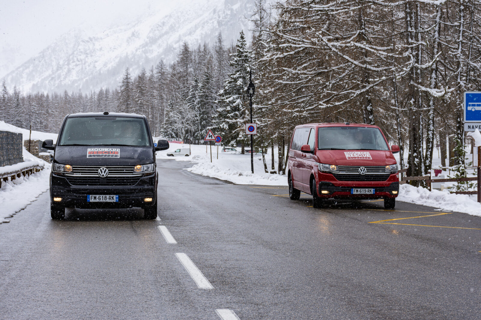 Black and white van parking on road with snow