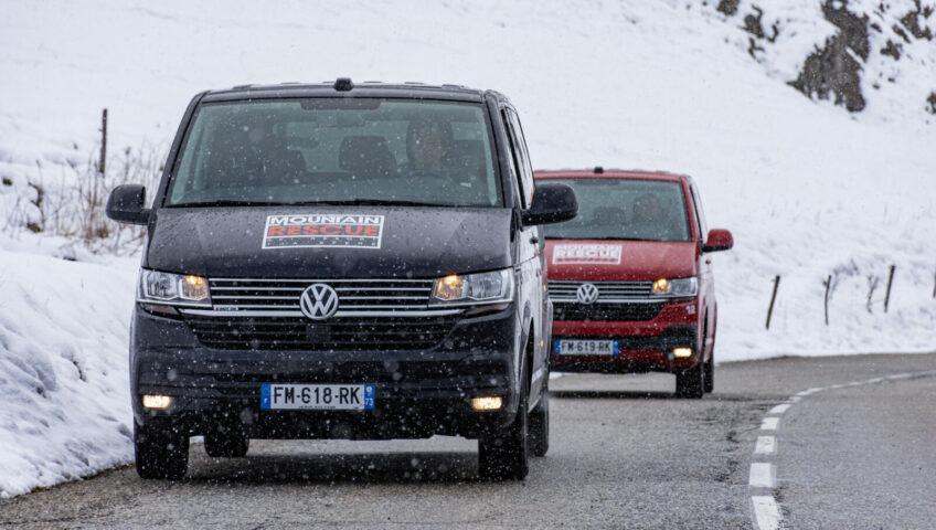 Close up of two Mountain Rescue ski vans driving at camera on mountain road