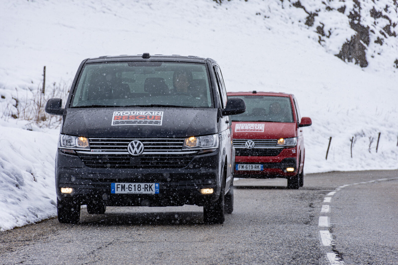 Close up of two Mountain Rescue ski vans driving at camera on mountain road