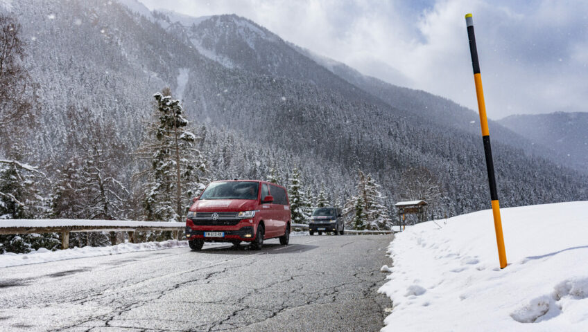 Two transfer vans driving towards you in snowy mountains