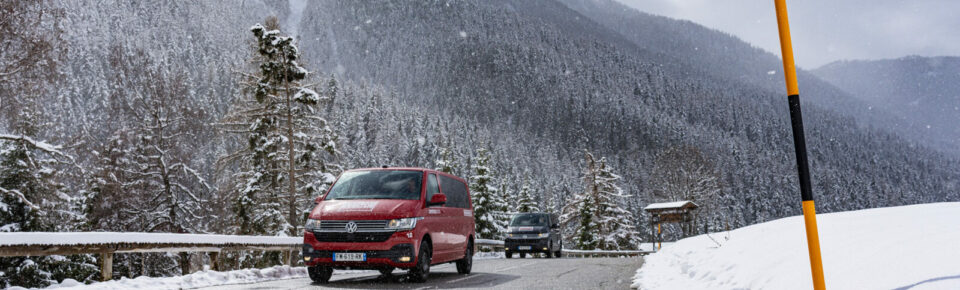Two transfer vans driving towards you in snowy mountains
