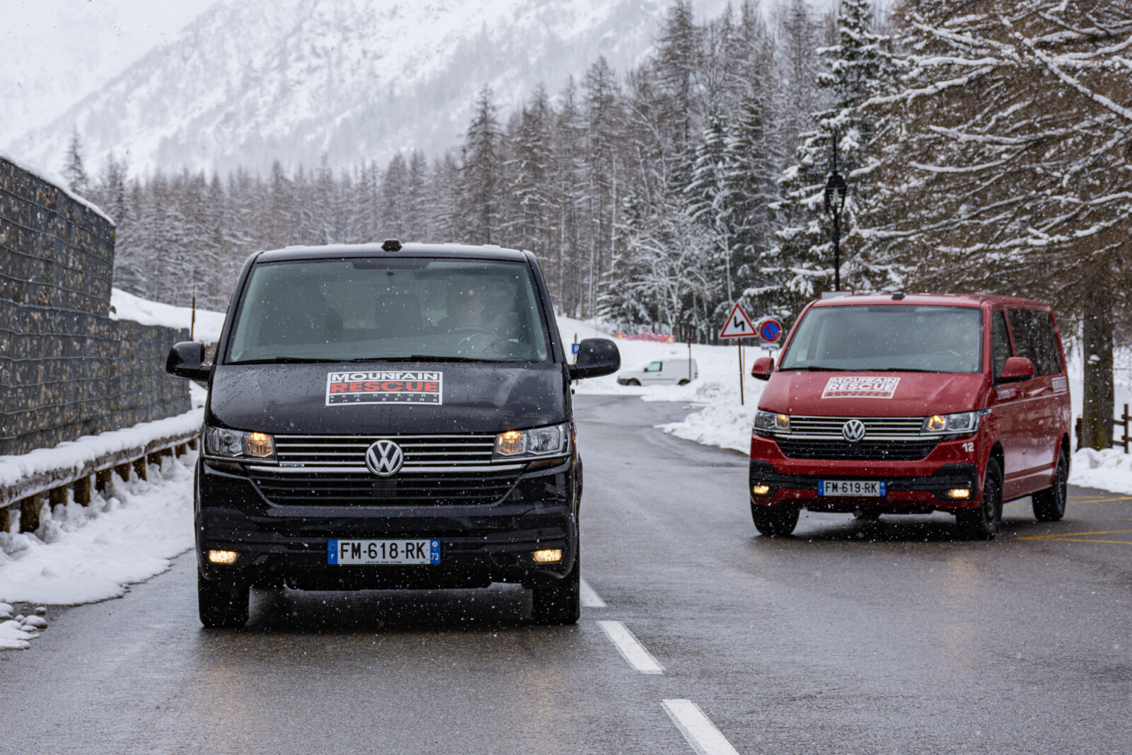Black and Red Mountain Rescue minibuses on alpine road