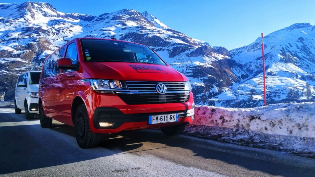 red and white VW Caravelle minibuses on mountain road